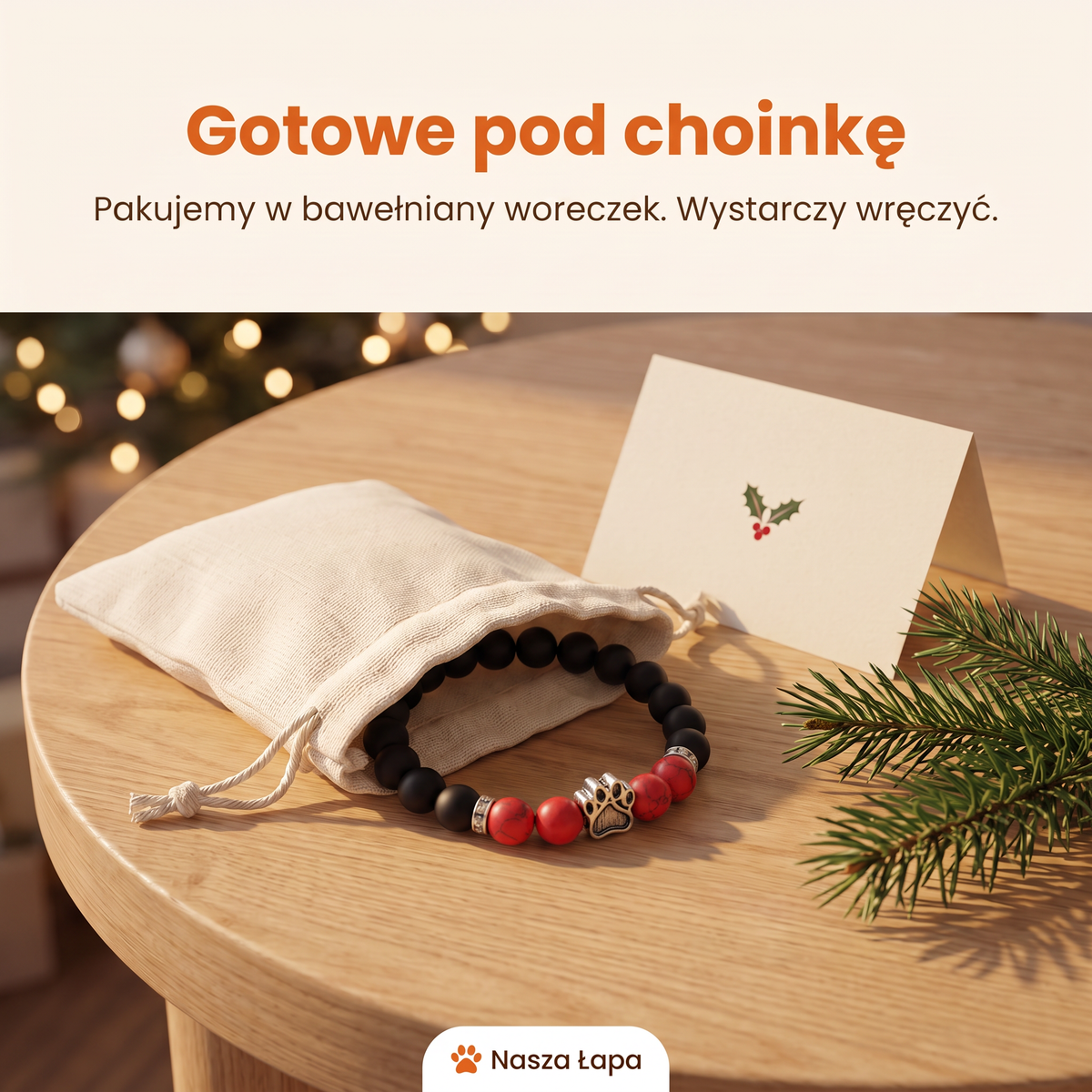 Bransoletka Jarzębina w bawełnianym woreczku obok świątecznej kartki, gotowe pod choinkę