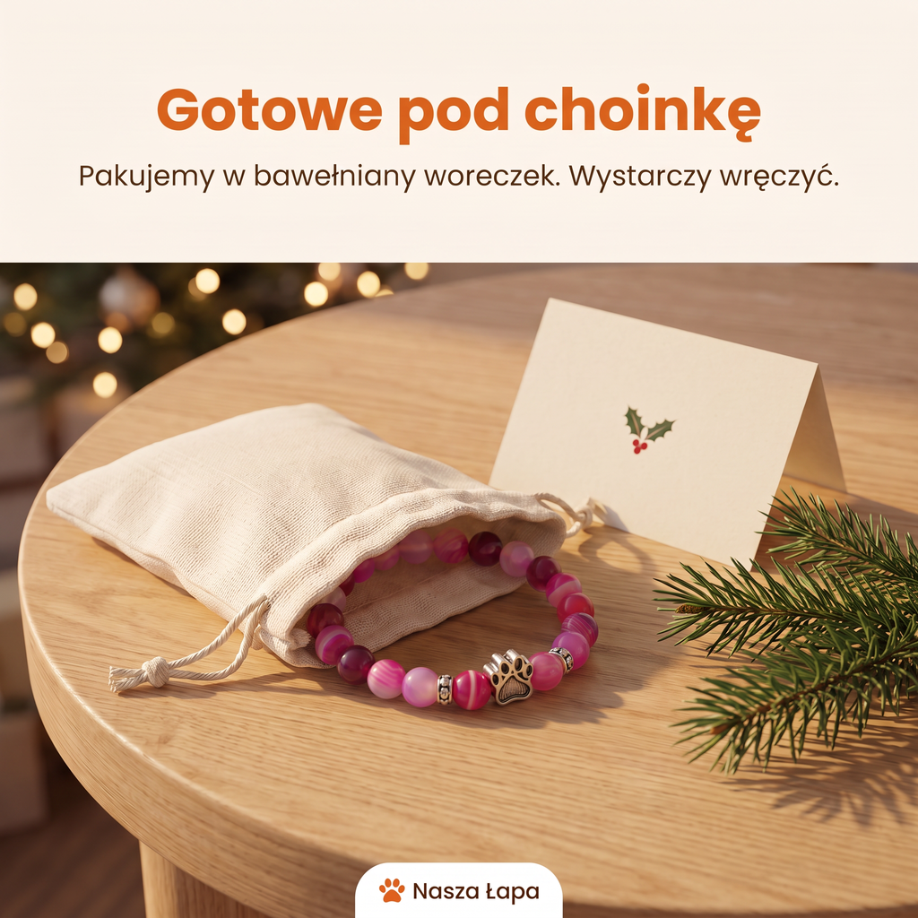 Bransoletka Poranna Zorza w bawełnianym woreczku obok świątecznej kartki, gotowe pod choinkę