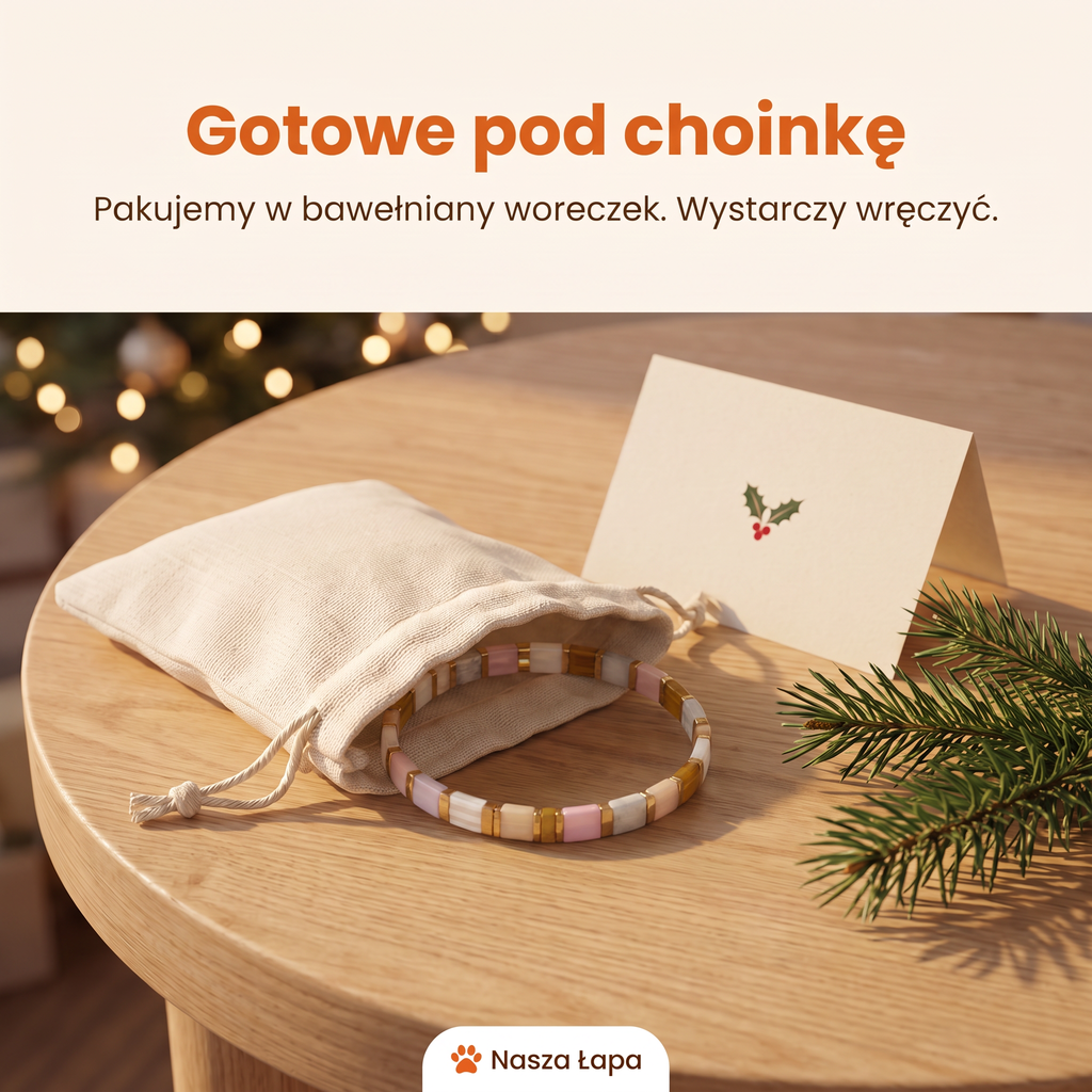 Bransoletka Tkana Różowy Nosek w bawełnianym woreczku obok świątecznej kartki, gotowe pod choinkę