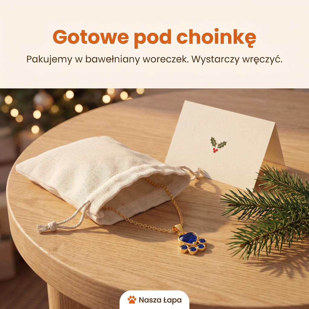 Naszyjnik Nocna Warta w bawełnianym woreczku obok świątecznej kartki, gotowe pod choinkę