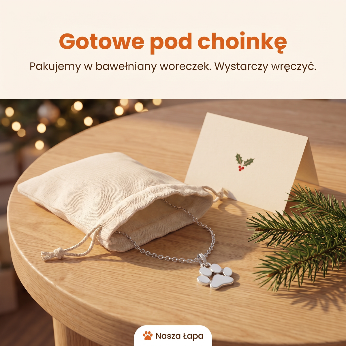 Naszyjnik Psi Uśmiech w bawełnianym woreczku obok świątecznej kartki, gotowe pod choinkę